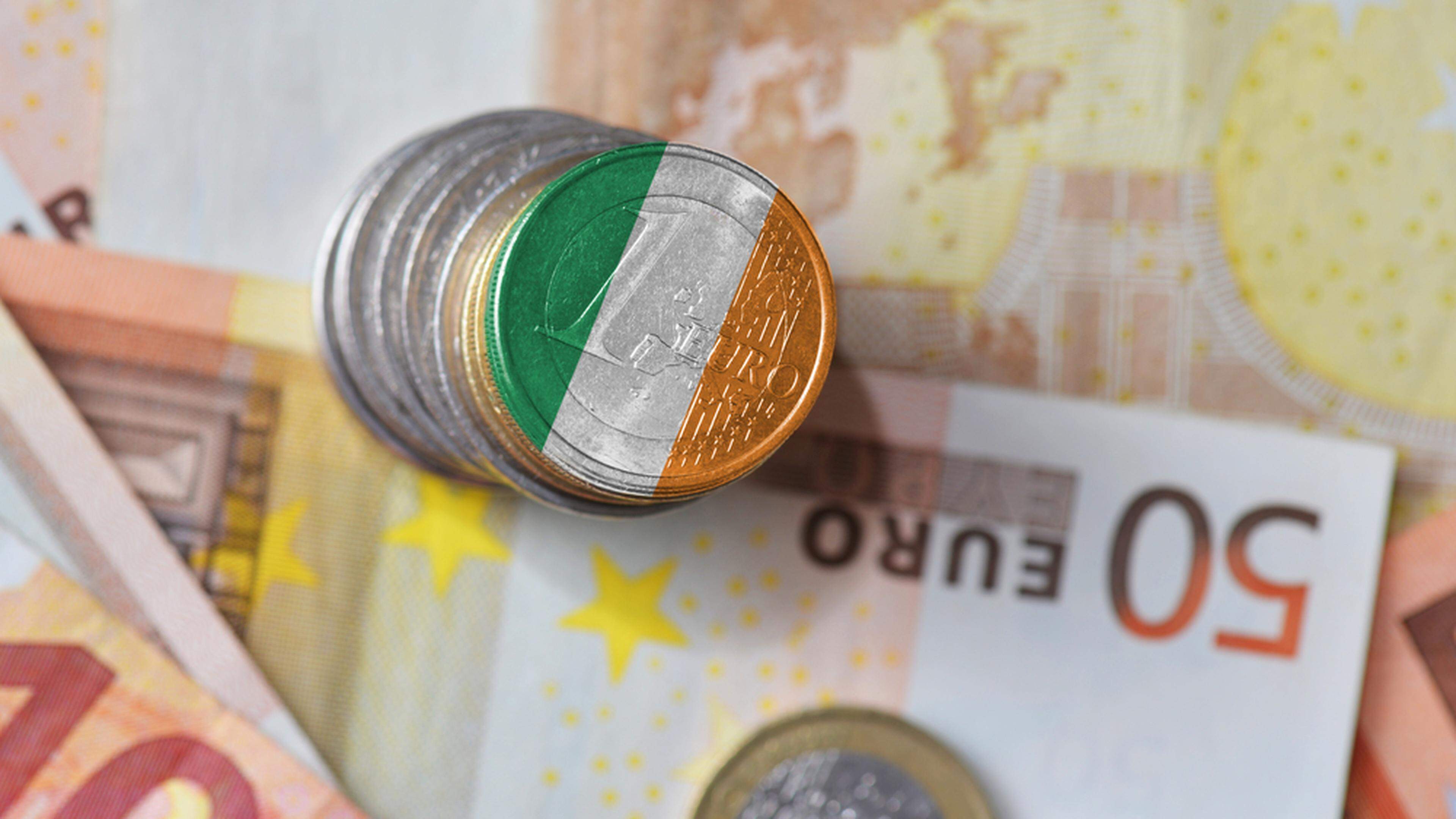 An undated illustration of a euro coin with the national flag of Ireland in the background.