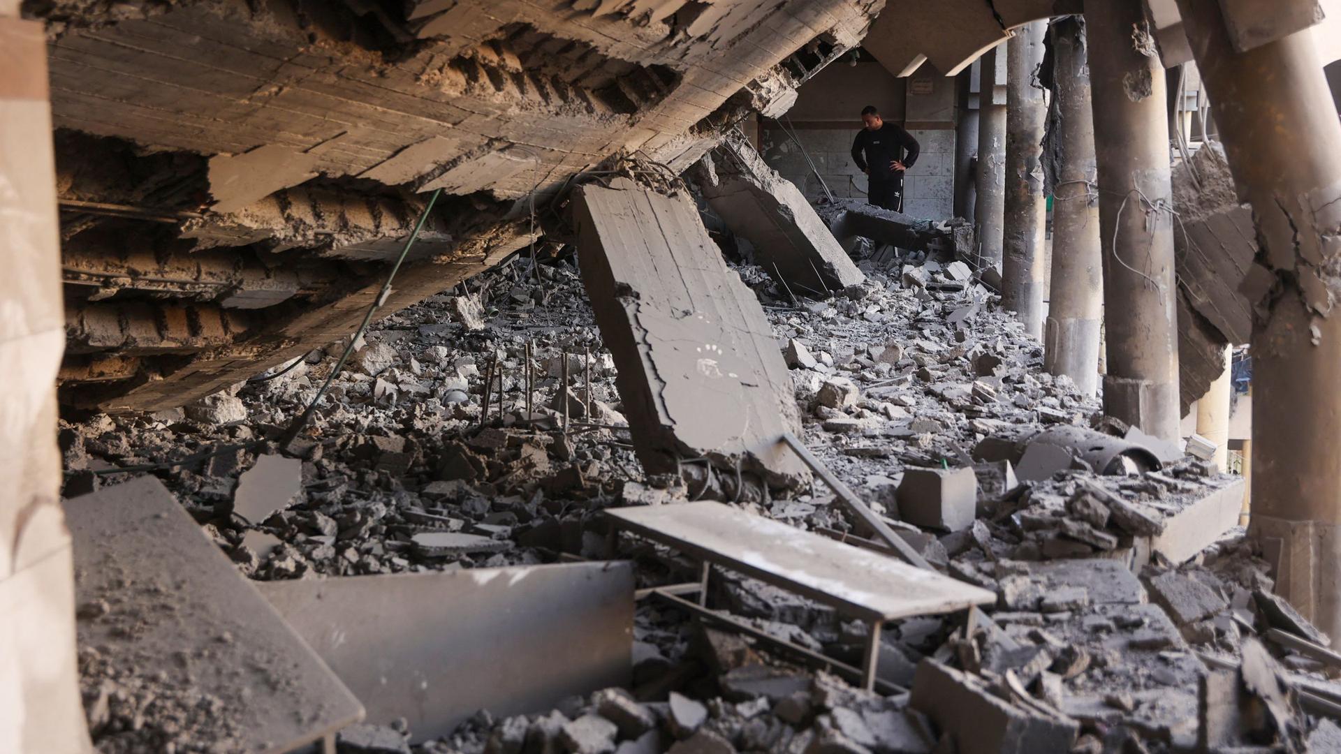 TOPSHOT - A man looks at the rubble of a destroyed section of a school-turned-camp following an Israeli strike in Gaza City on March 18, 2025.". Israel on March 18 unleashed its most intense campaign on the Gaza Strip since a January ceasefire, with Gaza civil defence agency saying 220 people killed, prompting Hamas to accuse Benjamin Netanyahu's government of torpedoing the truce. (Photo by Omar AL-QATTAA / AFP)