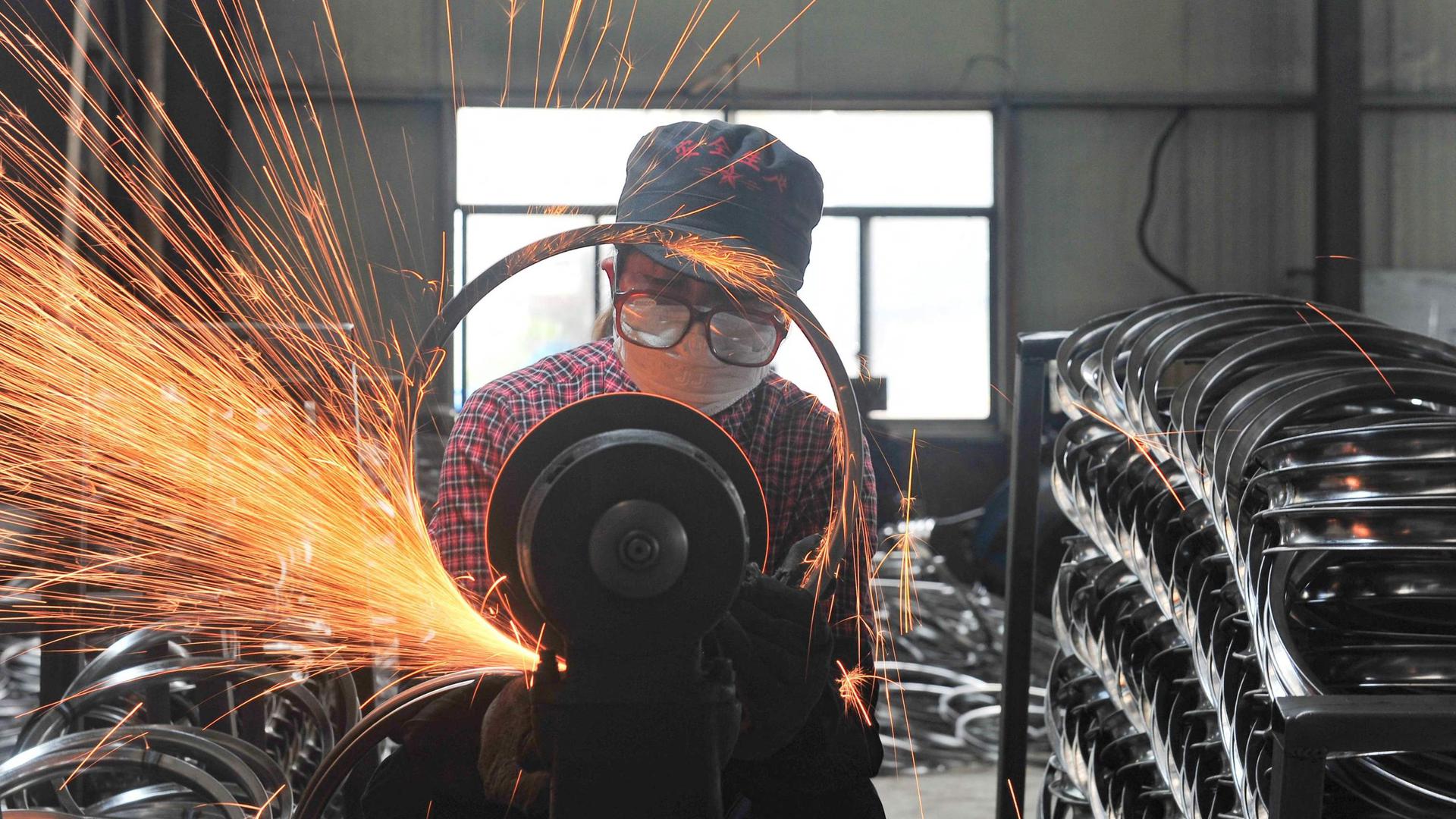 A factory worker welding wheels in Hangzhou, in China's eastern Zhejiang province, on Sunday