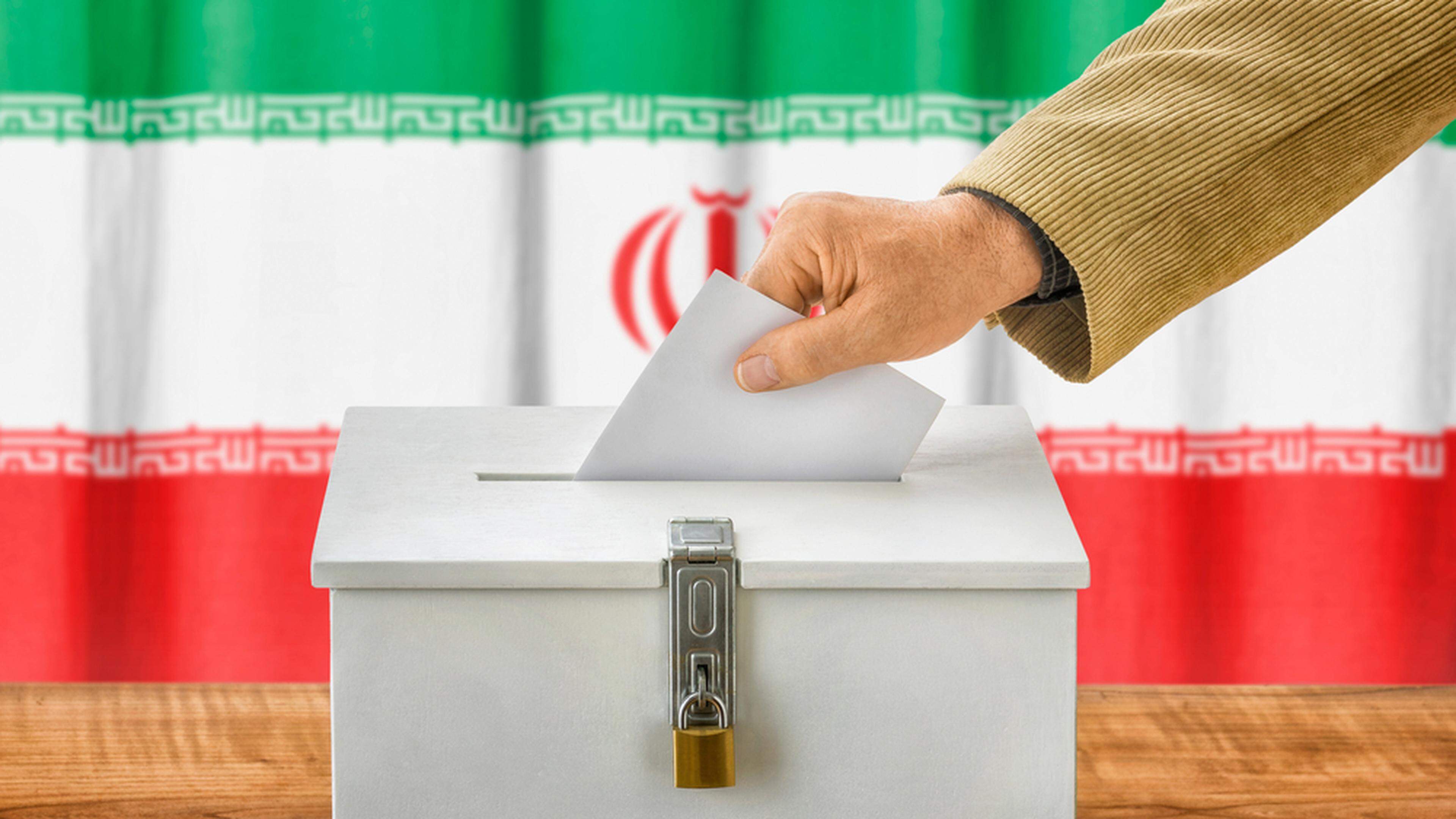Man putting a ballot into a voting box in Iran