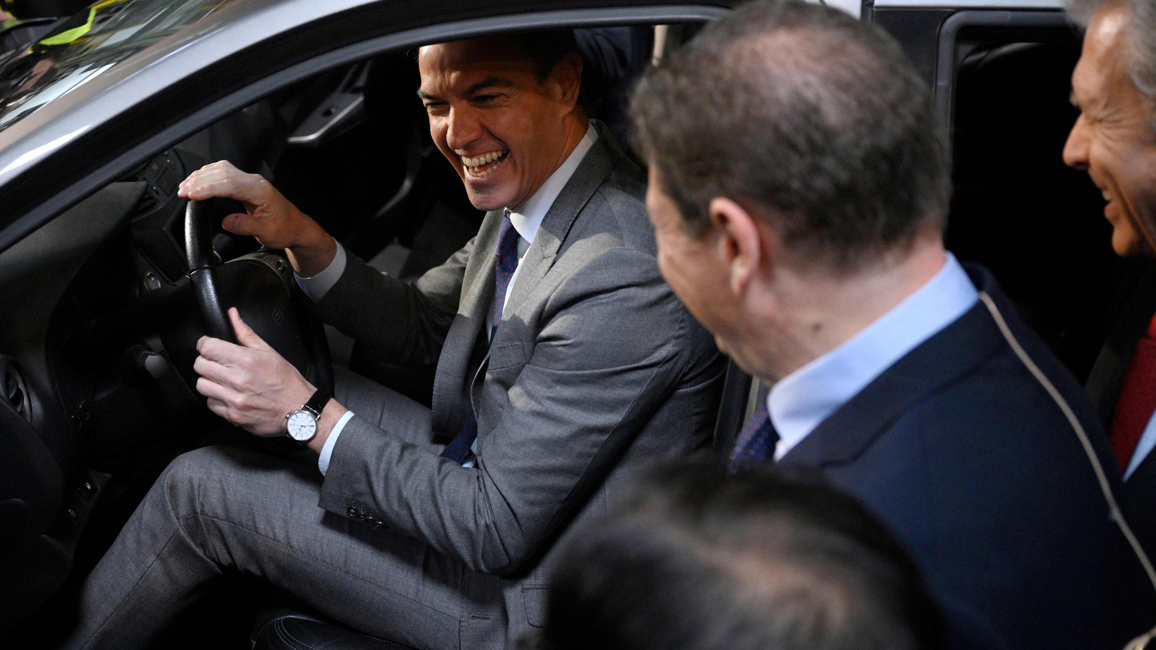 Spanish Prime Minister Pedro Sanchez laughs as he sits in a Omoda car by Ebro-EV Motors and Chinese carmaker Chery joint venture at the former Nissan factory in Barcelona on Friday. Chery will produce electric vehicles at the factory by the end of 2024. 