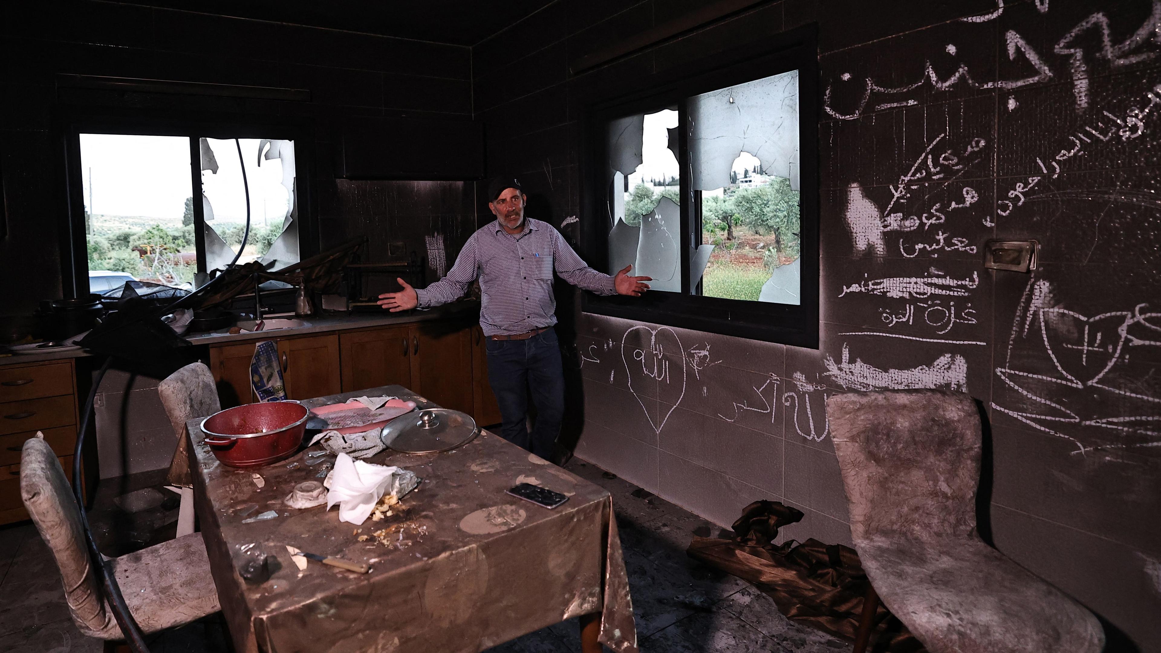 A Palestinian man gestures as he stands inside his kitchen on Wednesday after it was attacked by Israeli settlers in the occupied West Bank village of Al-Mughayyir near Ramallah.  