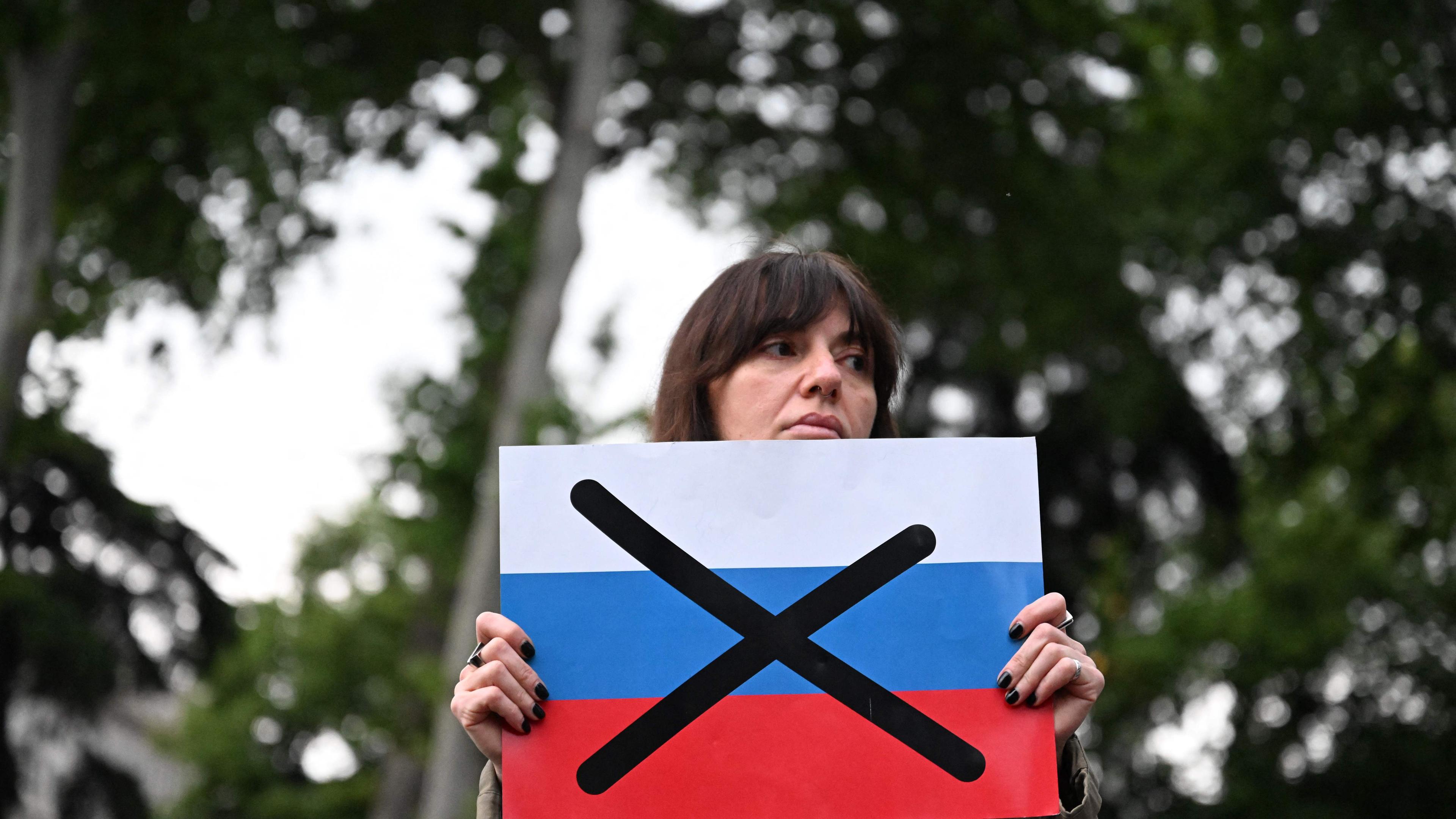 TOPSHOT - A protestor holds a crossed out flag of Russia during a rally on Friday against a  controversial "foreign influence" bill in Georgia.