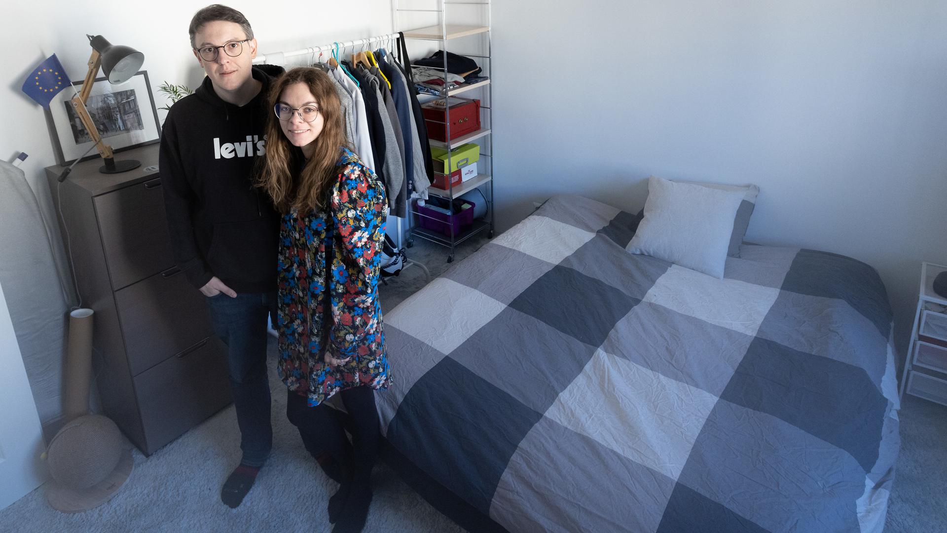 Benjamin Cler and Corina Darii stand in the spare bedroom they have prepared to welcome Ukrainian refugees