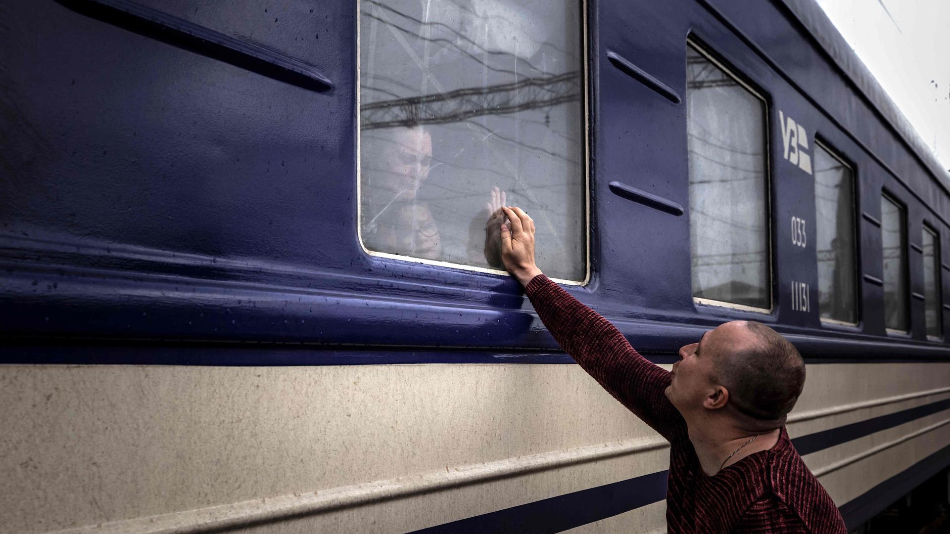 A man says goodbye to his family as they flee war-torn Ukraine