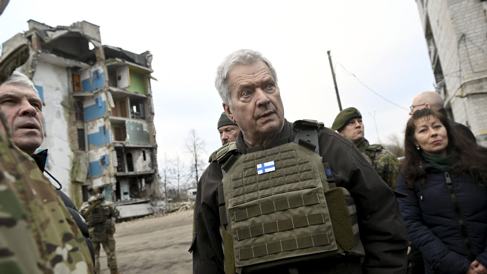 Finnish President Sauli Niinist� (C) and local officials and troops walk around the destroyed area in Borodyanka, a small Ukrainian town, some 60 km from the Ukrainian capital of Kyiv, on January 24, 2023. 