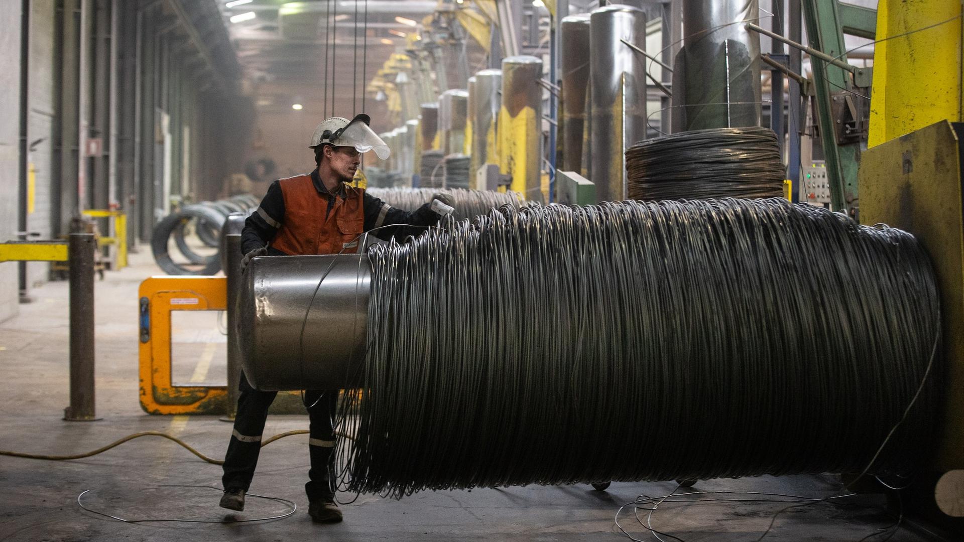 A worker handles steel wire at an ArcelorMittal factory in Luxembourg