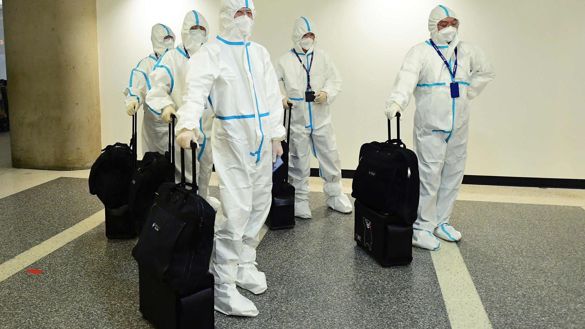 Flight crew from Air China arrive in hazmat suits in the international terminal at Los Angeles International Airport, 3 December, 2021.