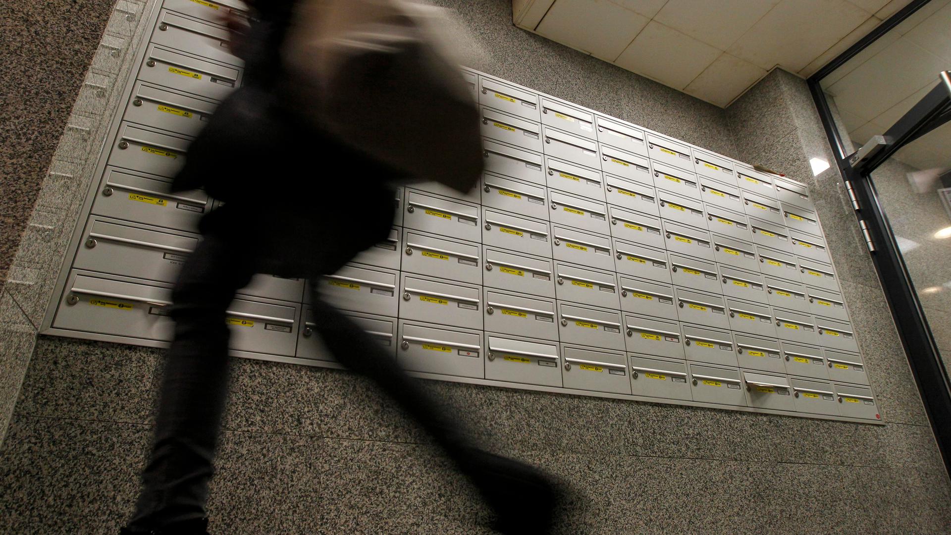 A man walks past a large number of letter boxes in this archive photo.