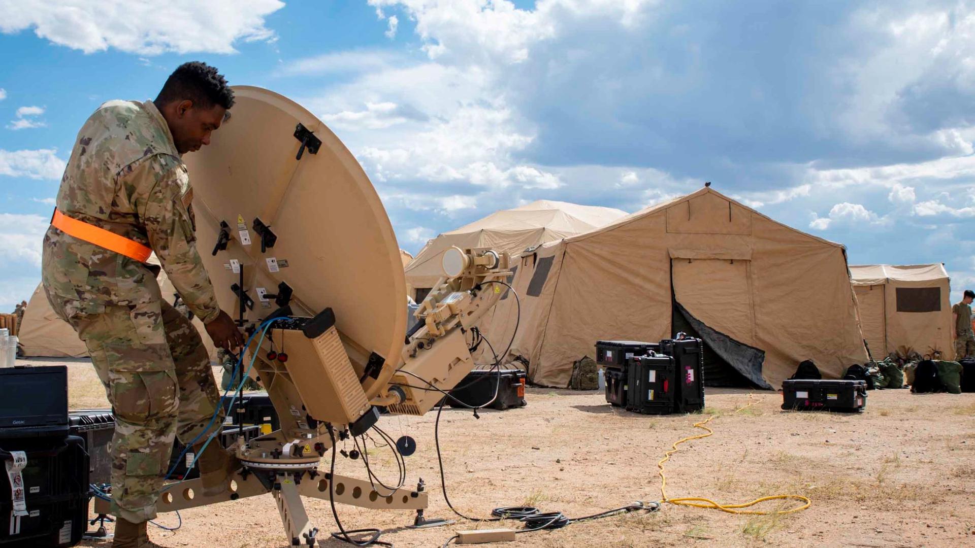 A US Air Force airman sets up a satellite in the Arizona desert during a training exercise in October 2021.