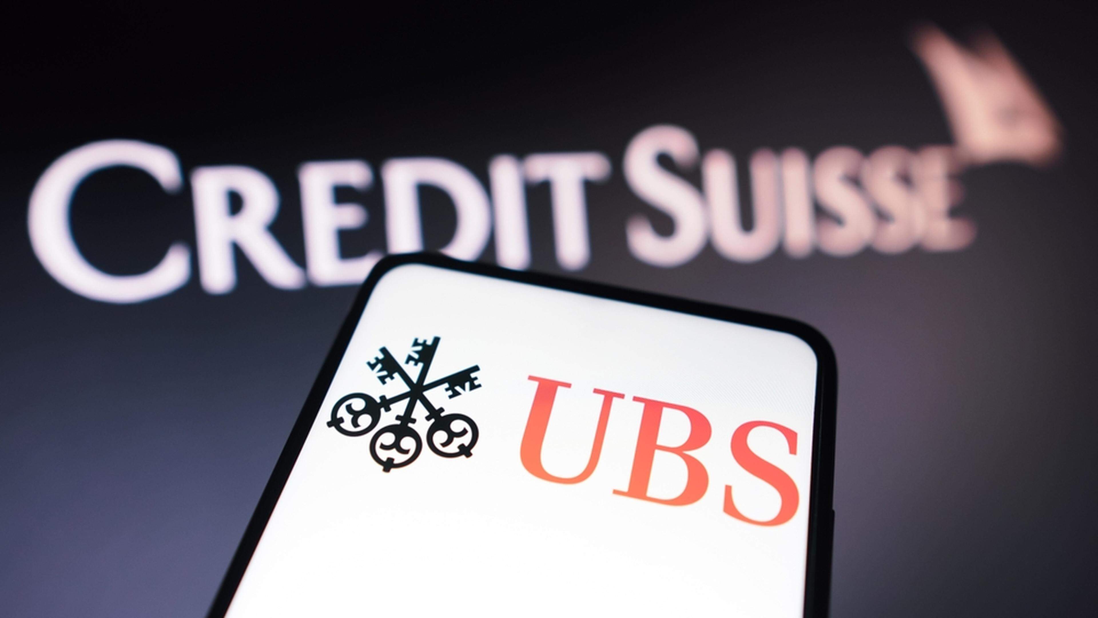 An illustration of the UBS logo displayed on a smartphone in front of the Credit Suisse logo, 22 March 2023.