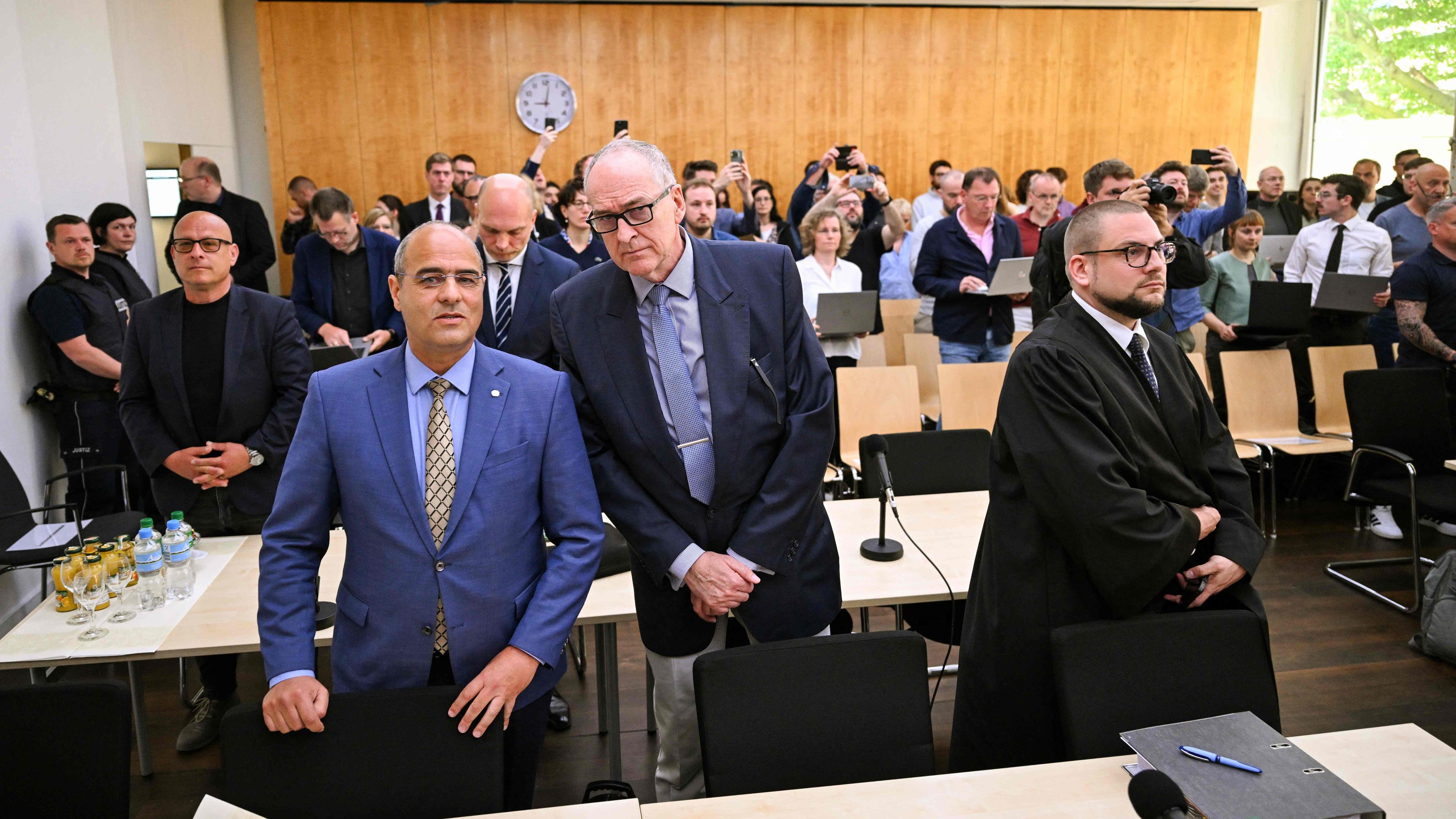 Peter Boehringer (L) and Roman Reusch (C), both members of Germany's far-right Alternative for Germany (AfD) party, and their lawywer Christian Conrad (R) wait for the verdict of the trial at the Higher Administrative Court in Muenster, western Germany on May 13, 2024.