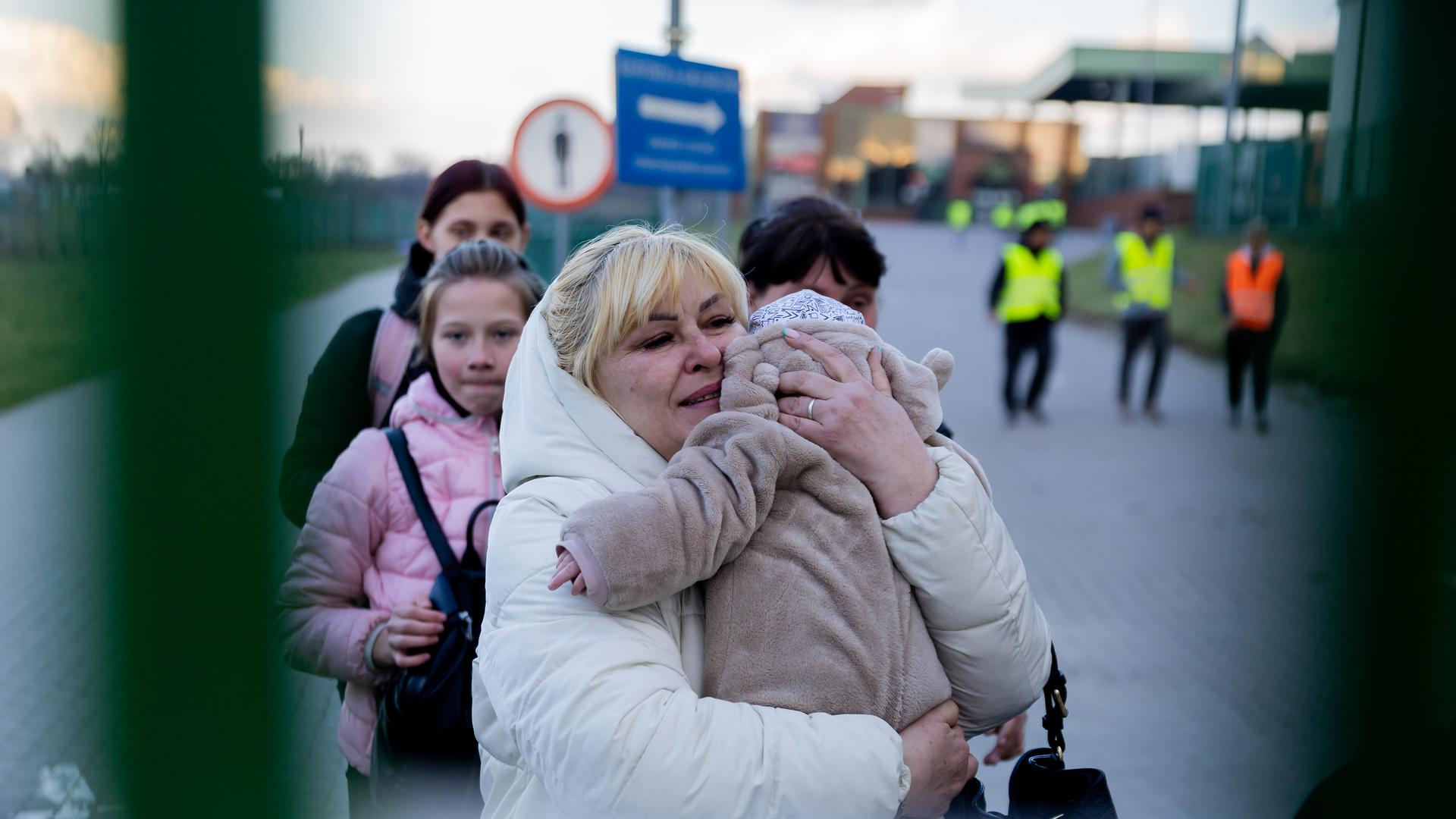 A woman holds her grandson at the Polish border
