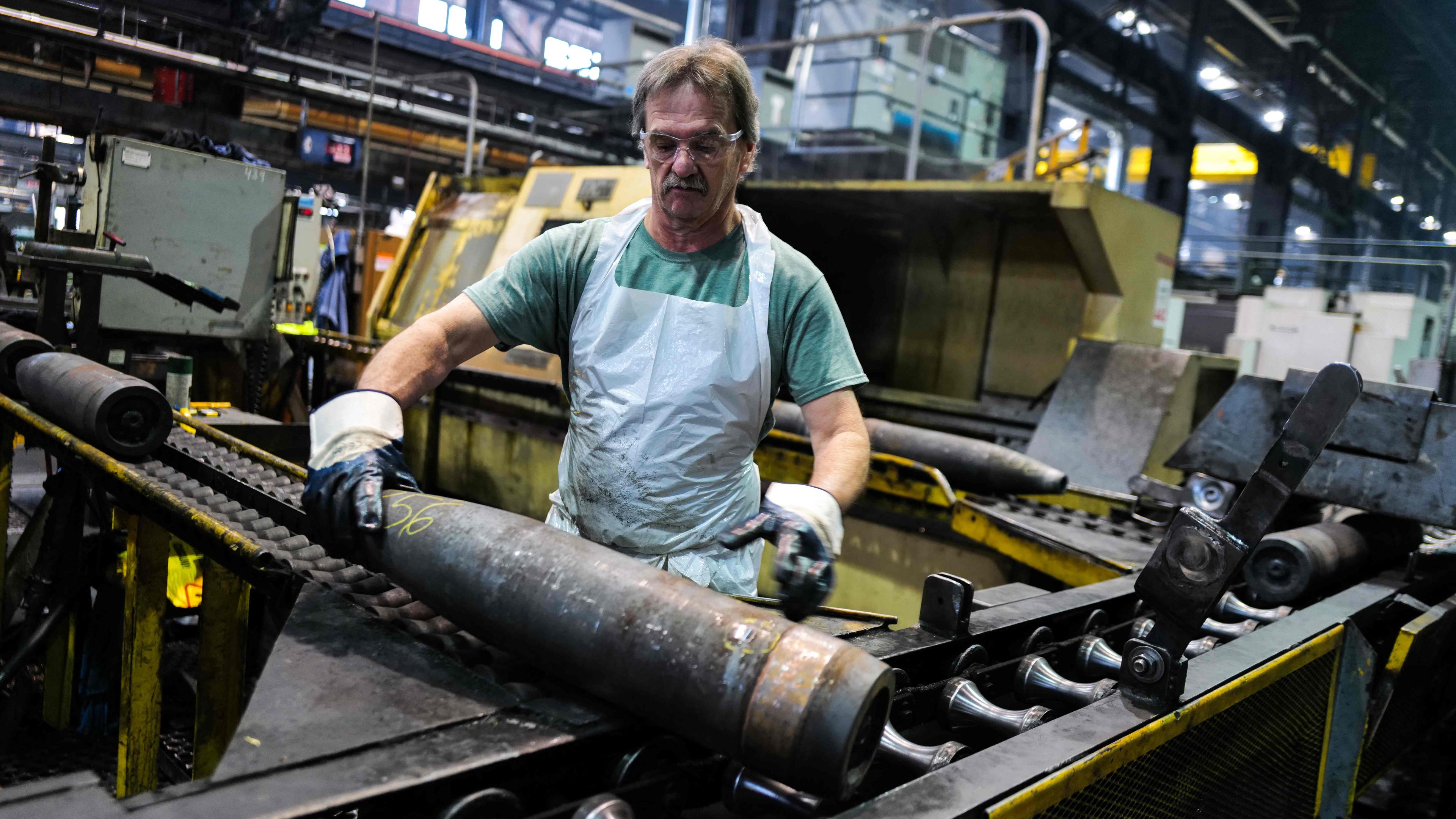 An employee at a US ammunition factory handles newly produced 155 mm caliber shells on Tuesday