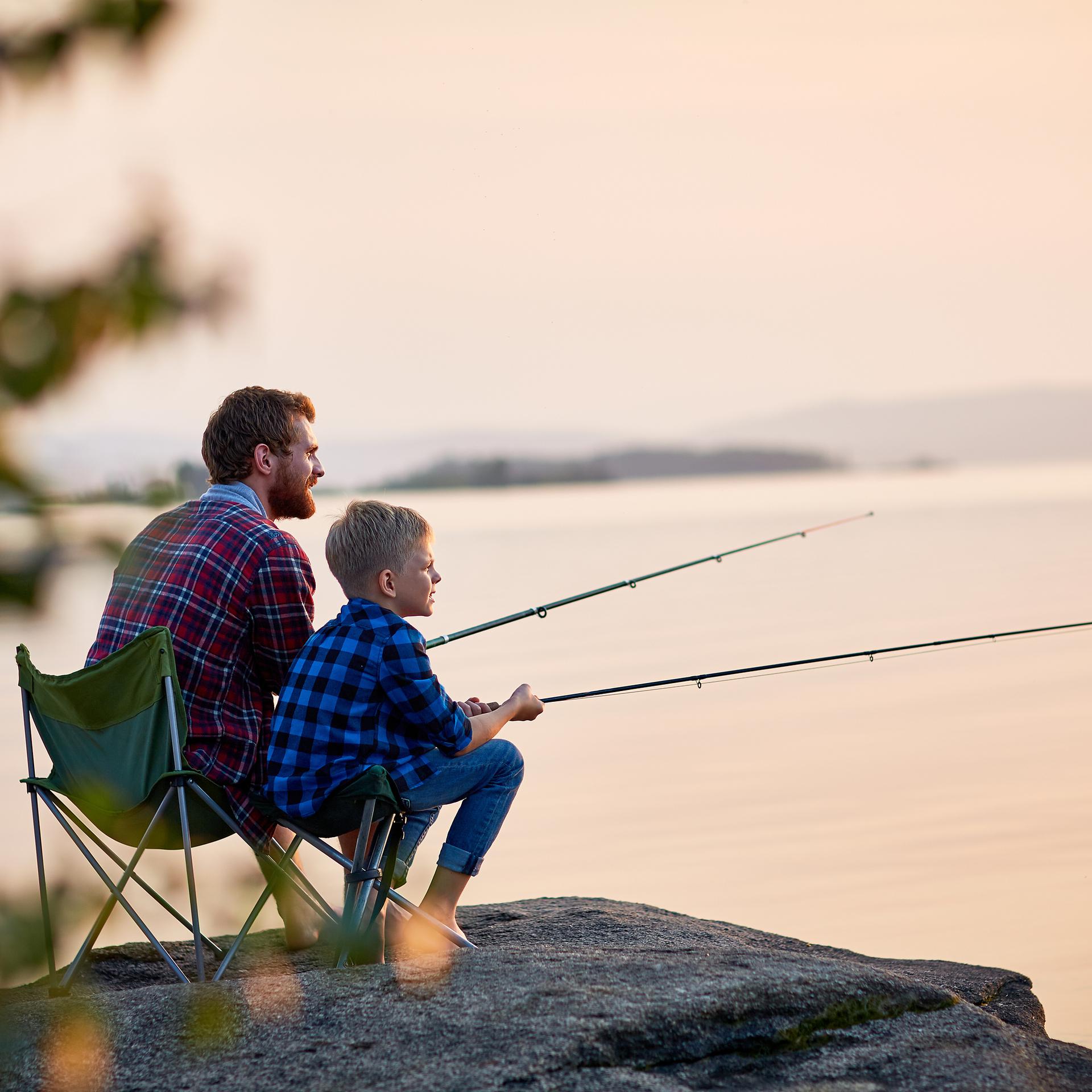 Senior man sitting on a beach chair with a fishing rod Stock Photo
